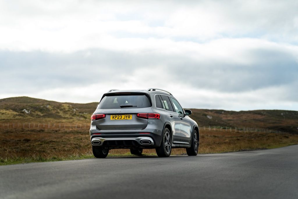 Modern SUV driving on a scenic countryside road during daytime.